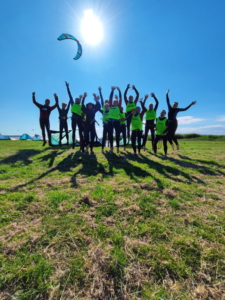 Kiteschüler mit Kite im Hintergrund nach einem Kitekurs in Saal an der Ostsee